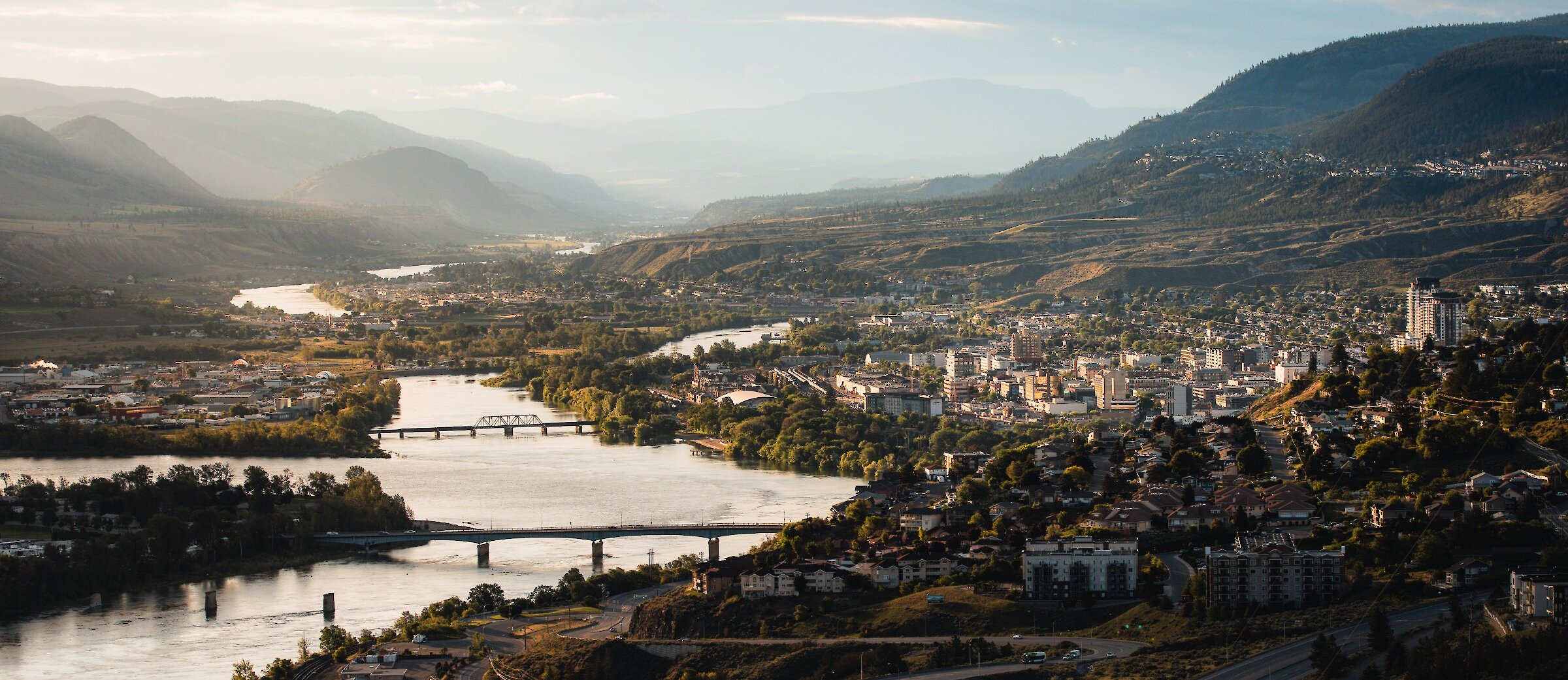 The Thompson River and city of Kamloops BC on a sunny day with a few clouds in the sky.