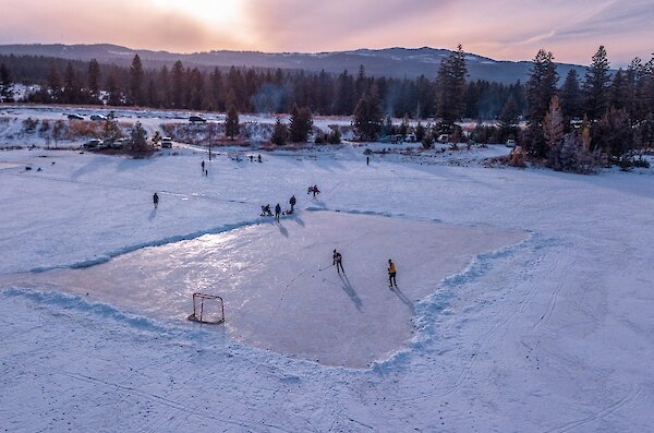 A group of skaters playing hockey on an outdoor rink at Inks Lake in Kamloops, BC.
