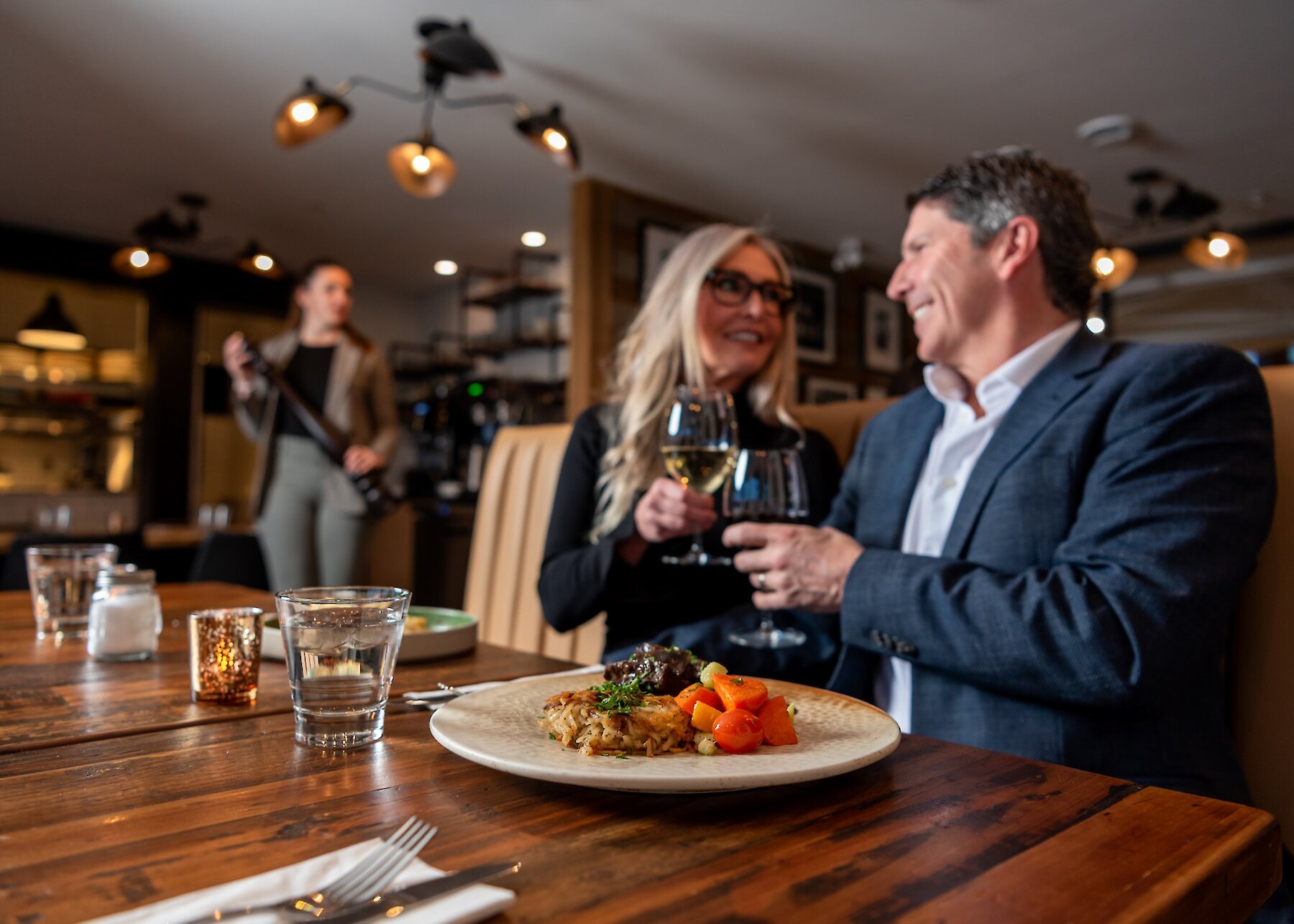 A couple cheers their wine glasses dining at Isagani Farm-to-Table in Kamloops, BC.