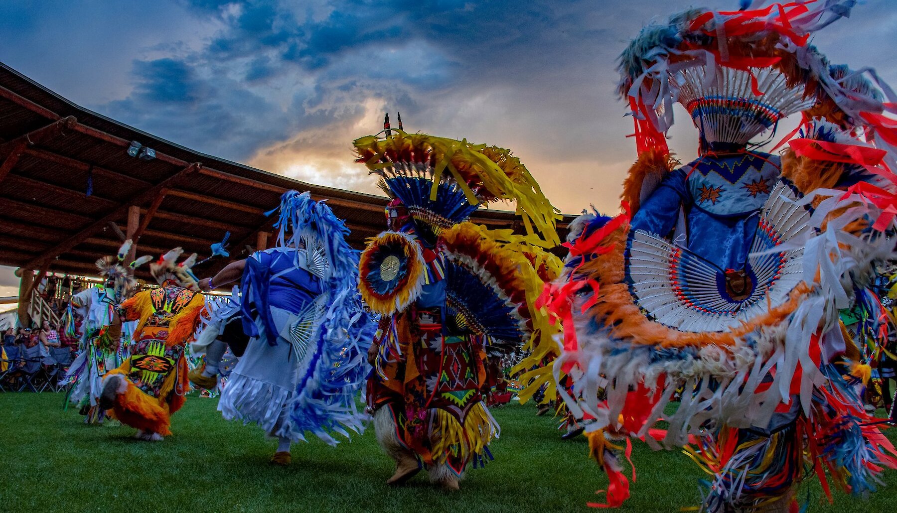 Vibrant Indigenous Dancers performing at the Kamloopa Powwow at the Tk̓emlúps te Secwépemc Special Events Facility (the Arbour) within Secwepemcúl’ecw.