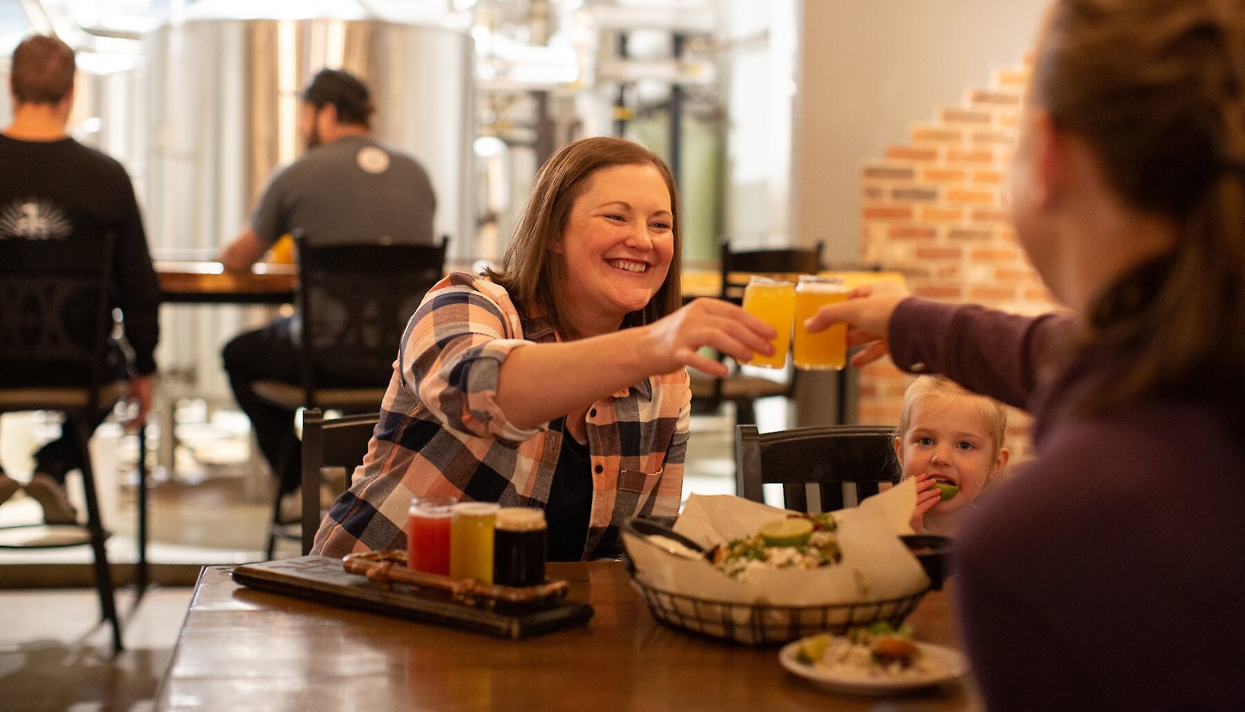 Two people sit at a table enjoying flights of beer and local food at Iron Road Brewing in Kamloops BC.