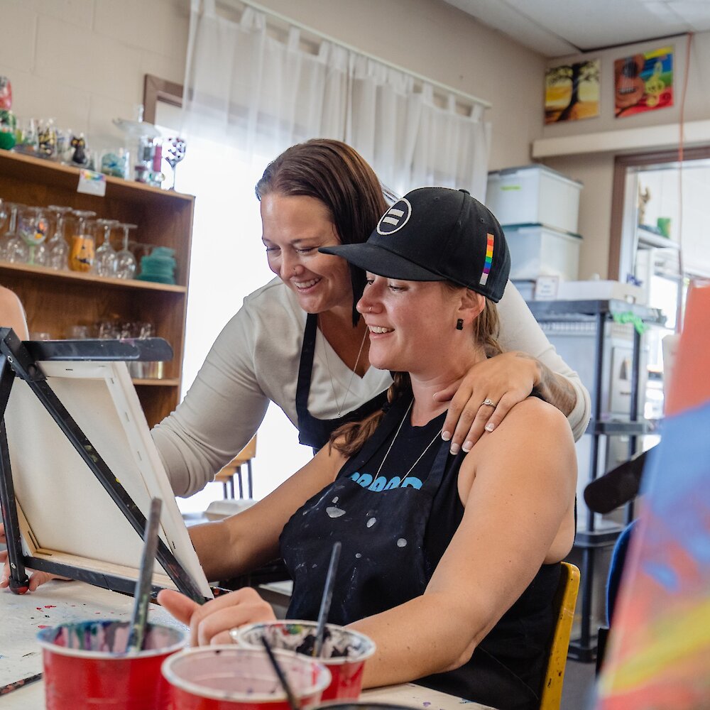 Hiker holds a light up the the hoodoos rock formations with a starry night sky in the background in Kamloops, BC.