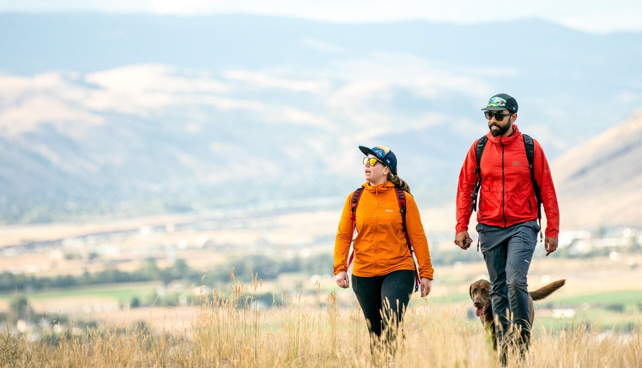 Couple walking their dog on a fall trail in Peterson Creek Park in Kamloops.