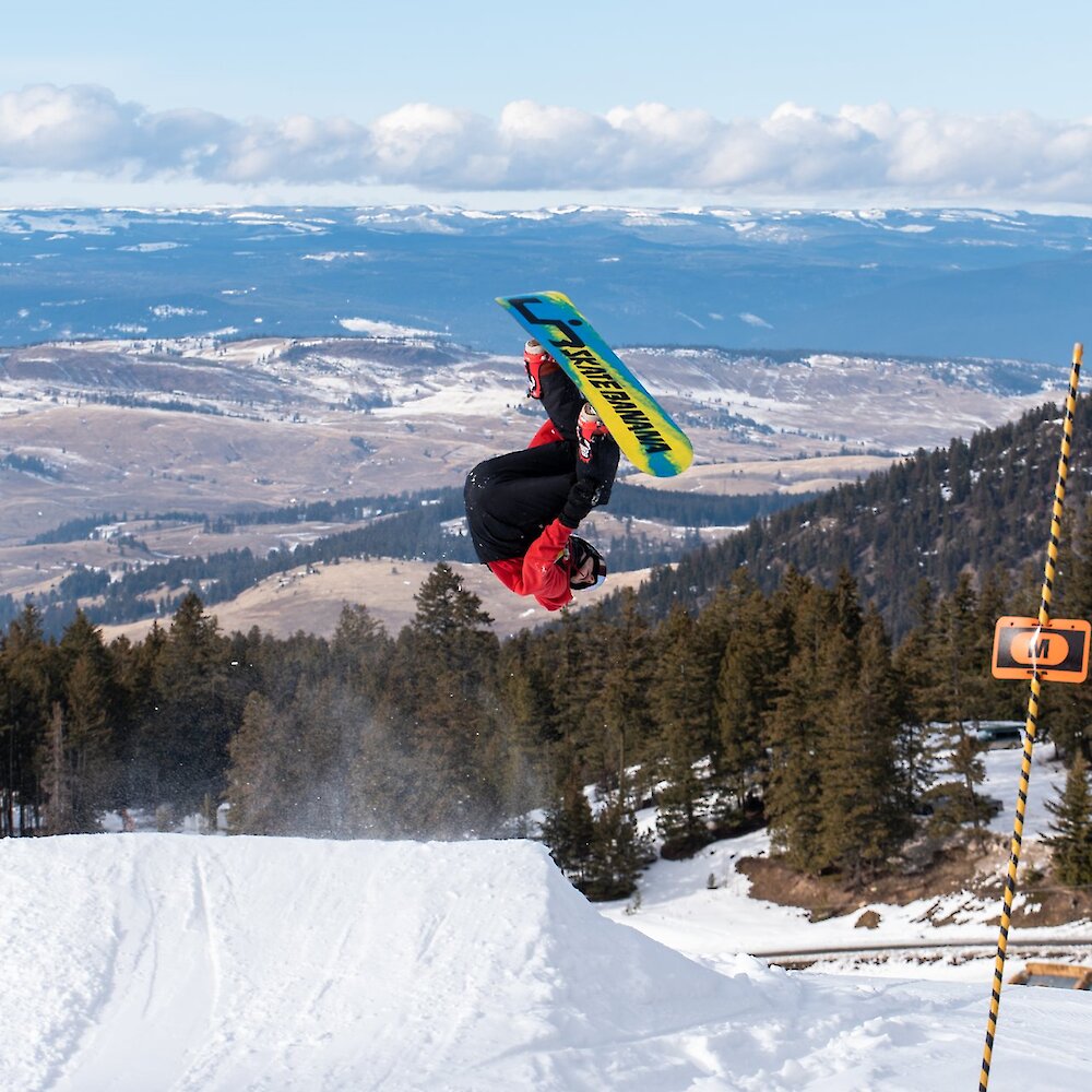 A snowboarder seen mid-air after taking a jump at Harper Mountain near Kamloops BC.
