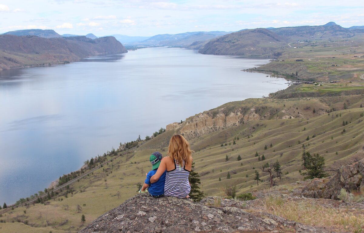 A Mother and son admiring the view over Kamloops Lake from a hiking viewpoint in Kamloops, BC.
