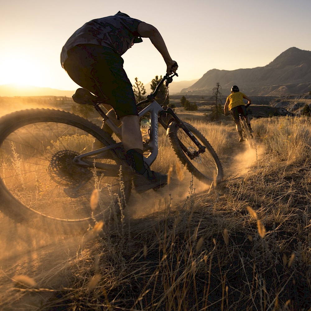 Mountain bikers riding the Coyote Crossing Trail in Kamloops at sunset.