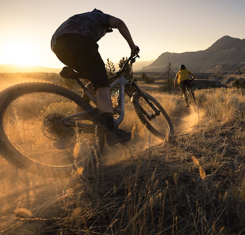 Mountain bikers riding the Coyote Crossing Trail in Kamloops at sunset.