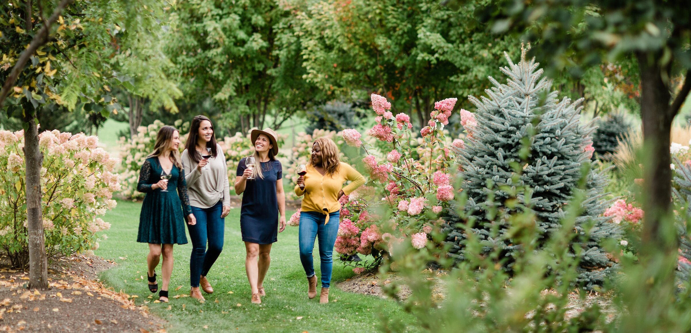 4 women walking though Privato Winery & Vineyard gardens