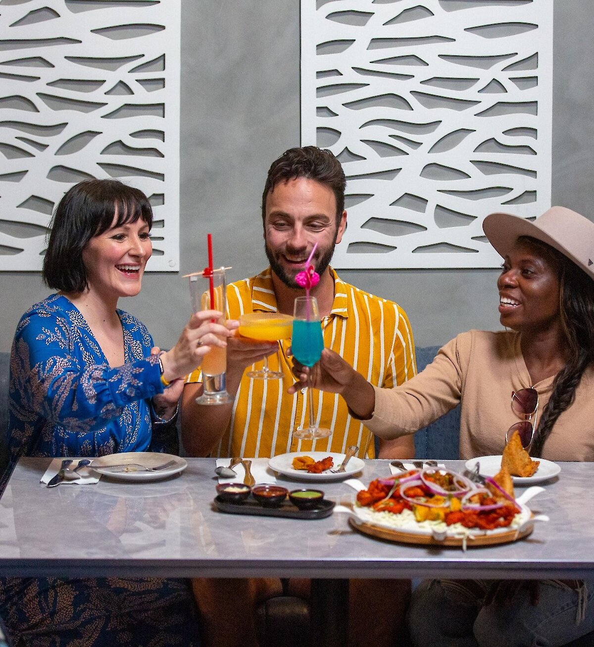 A group cheers their cocktails dining at Maaza Indian Kitchen + Bar in Kamloops, BC.