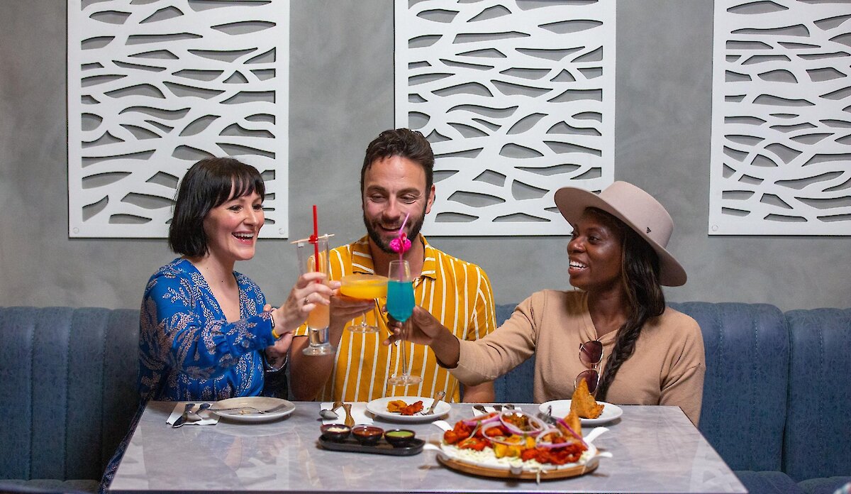A group cheers their cocktails dining at Maaza Indian Kitchen + Bar in Kamloops, BC.