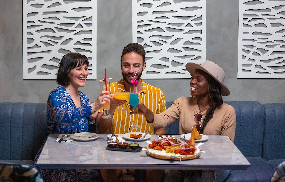 A group cheers their cocktails dining at Maaza Indian Kitchen + Bar in Kamloops, BC.