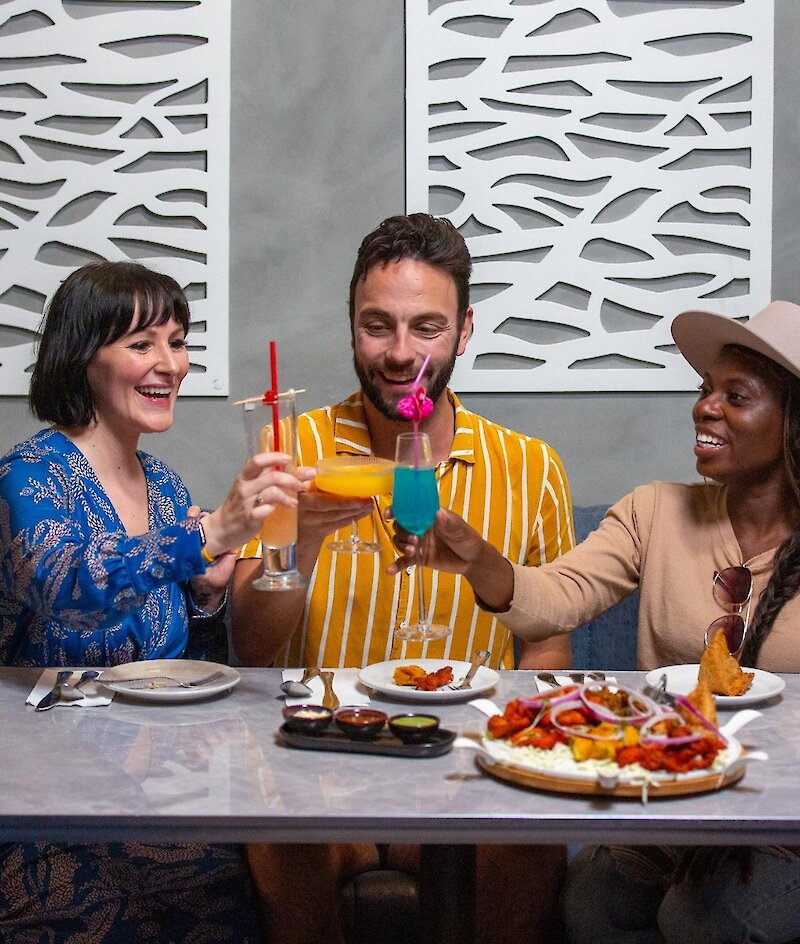 A group cheers their cocktails dining at Maaza Indian Kitchen + Bar in Kamloops, BC.
