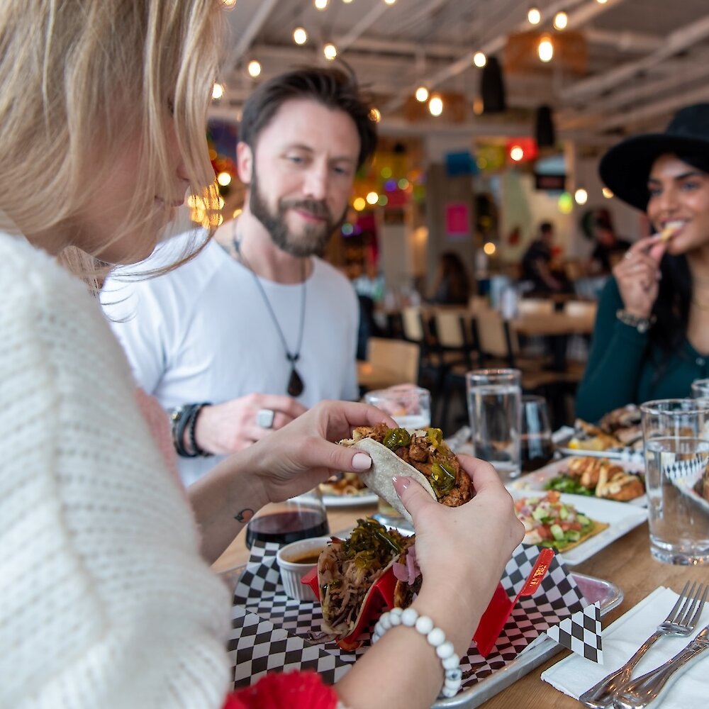 A group of friends eating at Yew Street Food Hall on the North Shore in Kamloops, BC.
