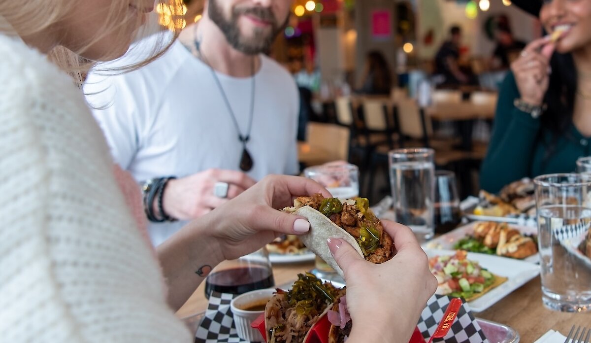 A group of friends eating at Yew Street Food Hall on the North Shore in Kamloops, BC.