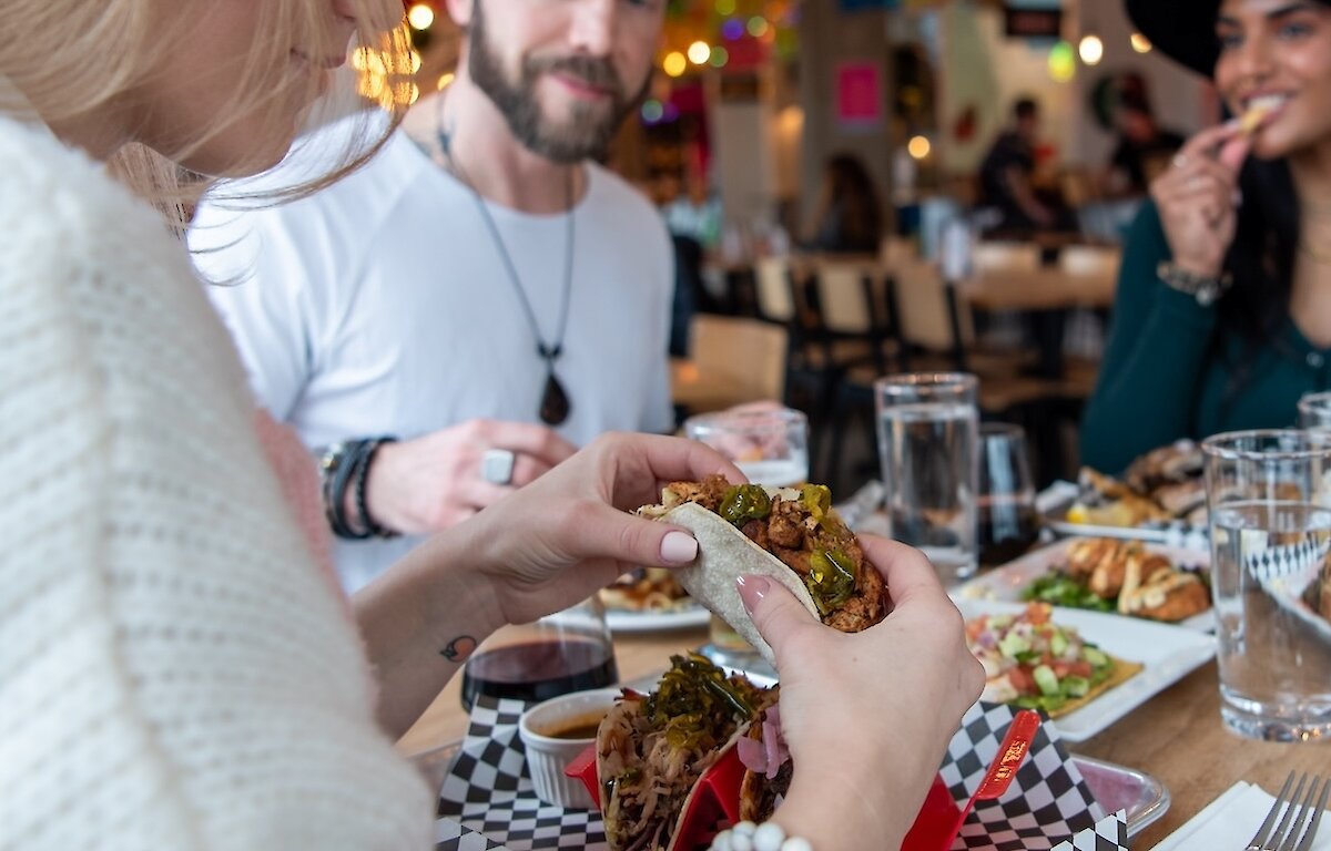 A group of friends eating at Yew Street Food Hall on the North Shore in Kamloops, BC.