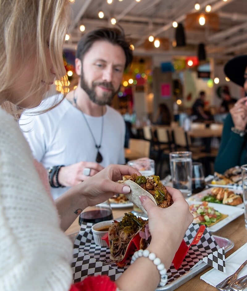 A group of friends eating at Yew Street Food Hall on the North Shore in Kamloops, BC.