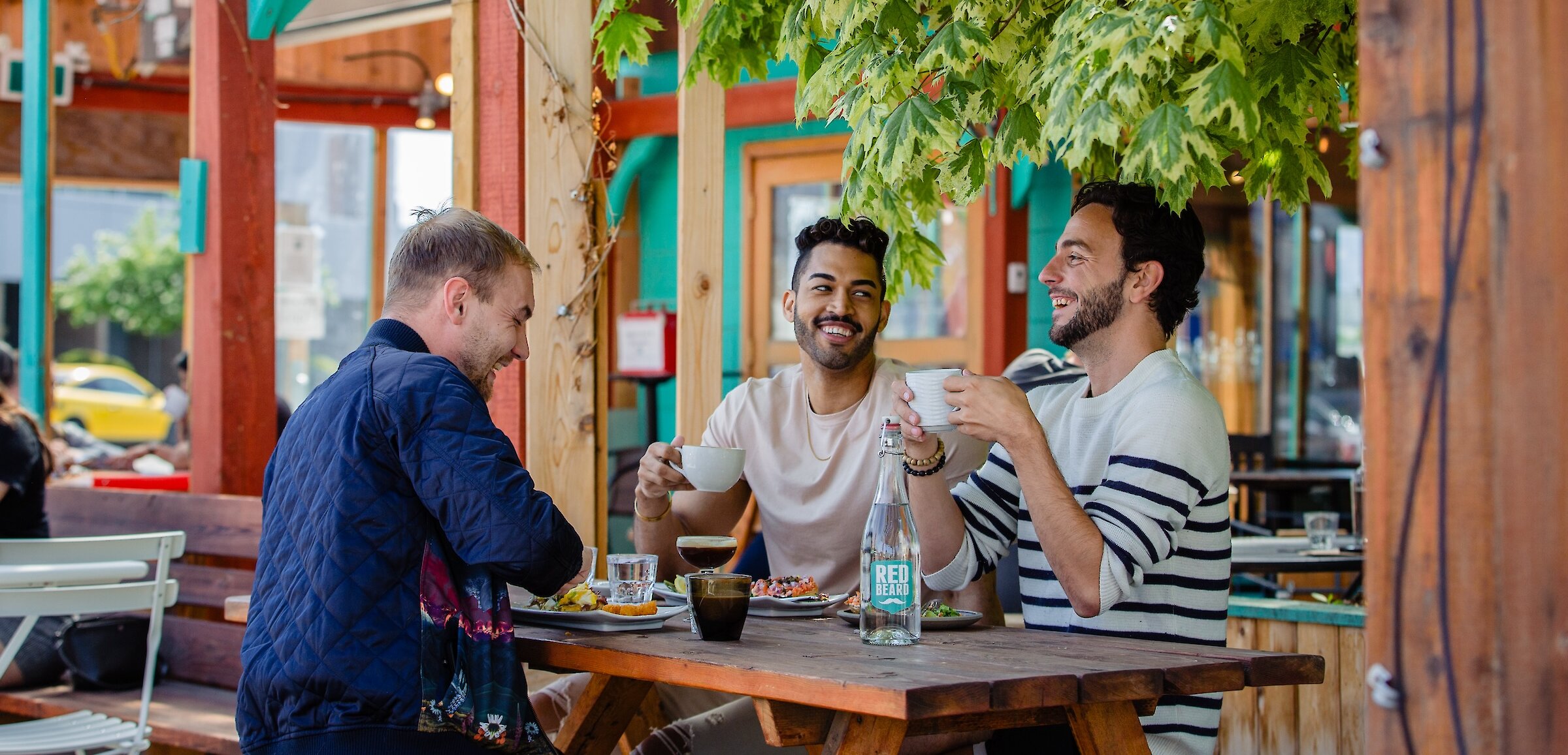 Three people eating at an outdoor patio restaurant table in Kamloops.