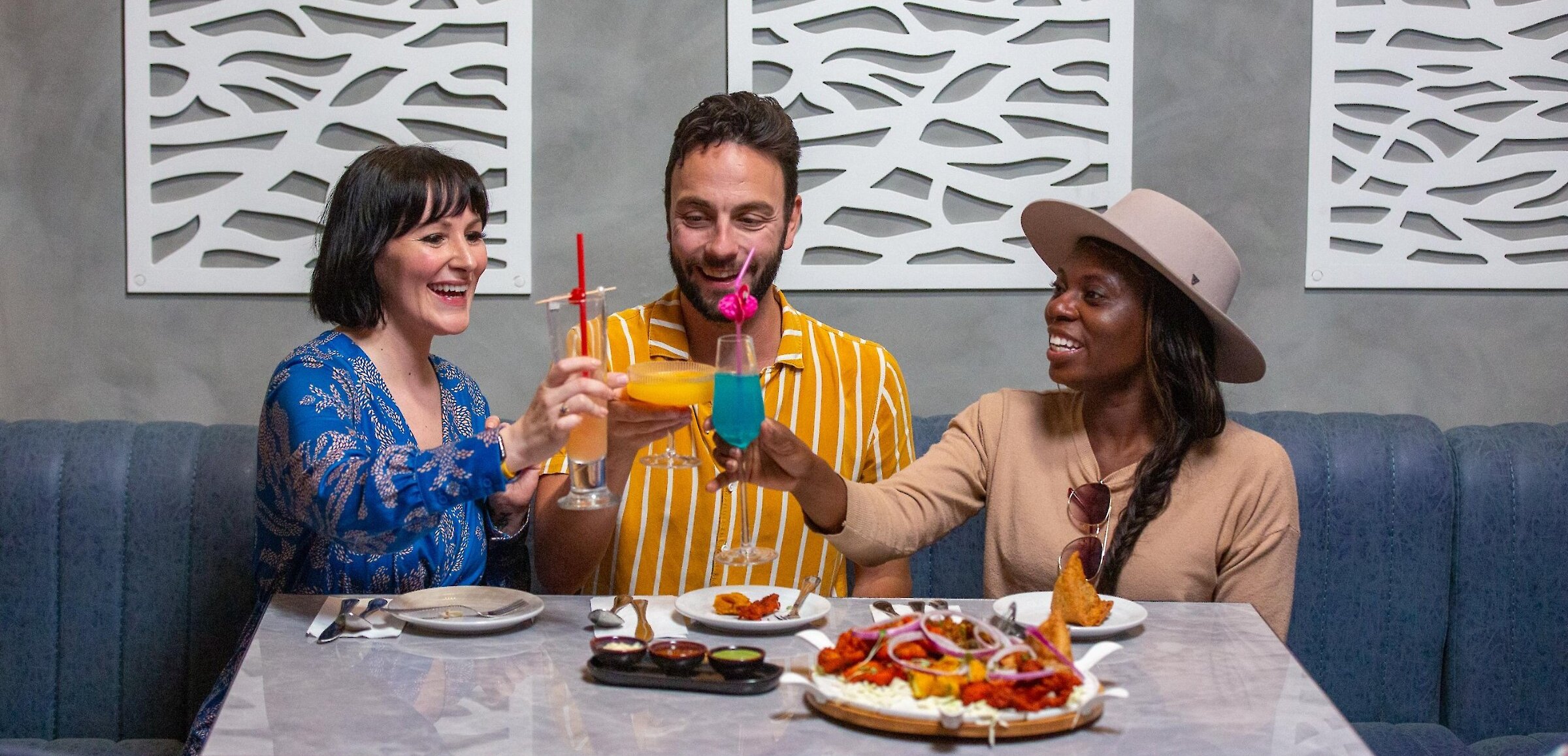 A group cheers their cocktails dining at Maaza Indian Kitchen + Bar in Kamloops, BC.