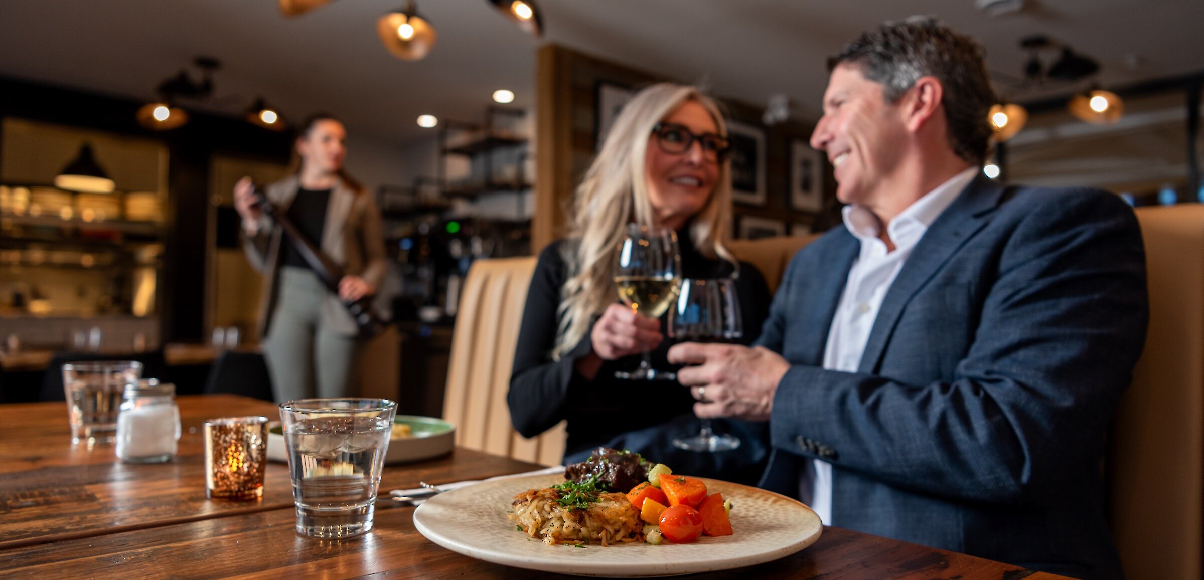 A couple cheers their wine glasses dining at Isagani Farm-to-Table in Kamloops, BC.