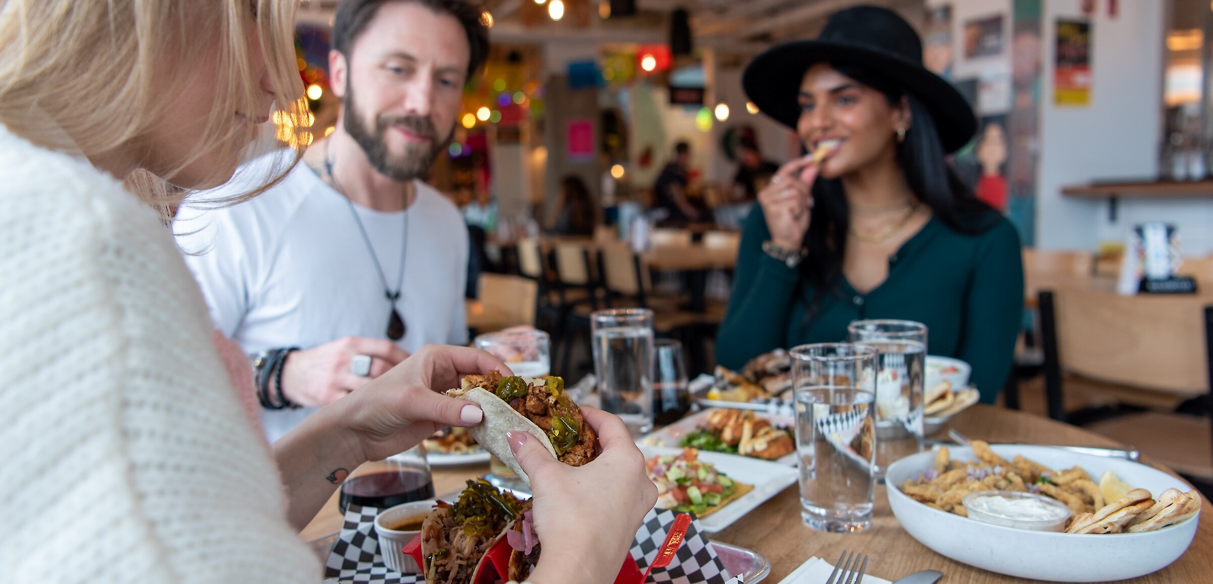 A group of friends eating at Yew Street Food Hall on the North Shore in Kamloops, BC.