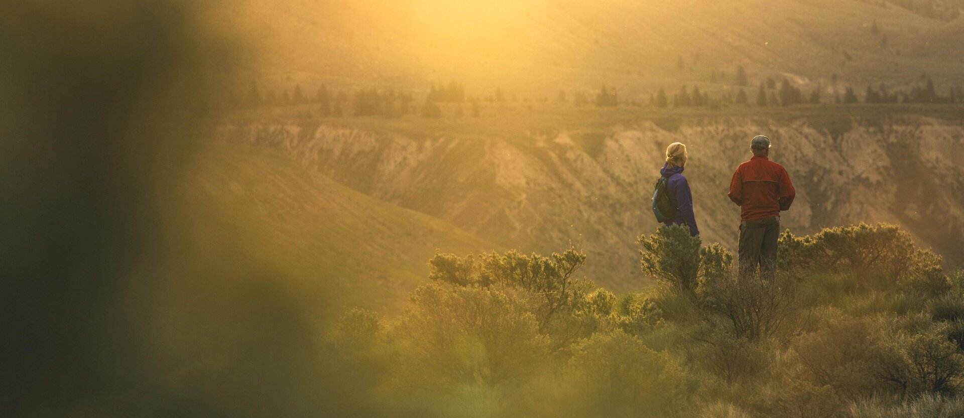 Two hikers enjoying the sunset in Kamloops, BC.