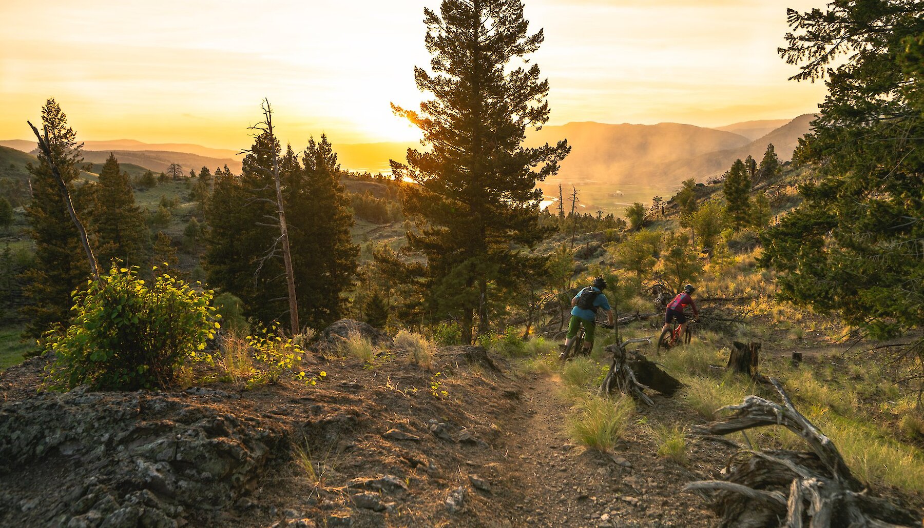 Two people ride through Kenna Cartwright Park at sunset in Kamloops BC