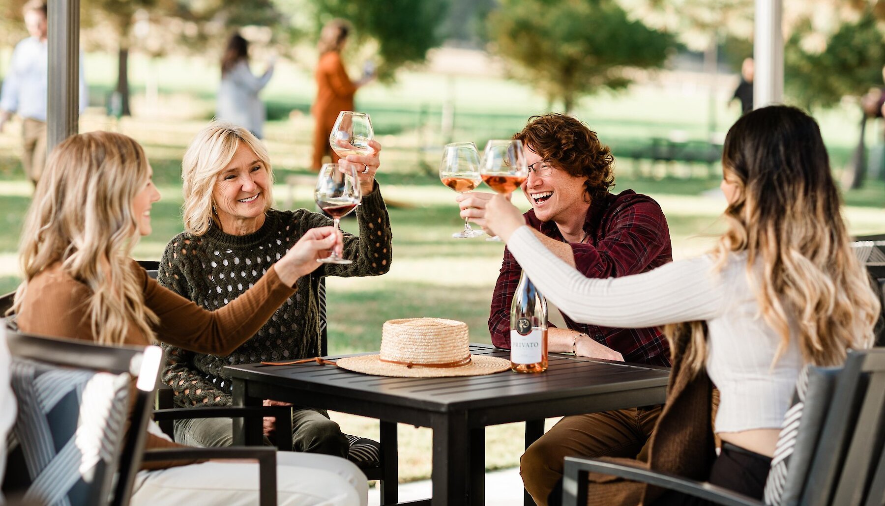 A group cheers their wine on the sunny Privato patio in Kamloops, BC.
