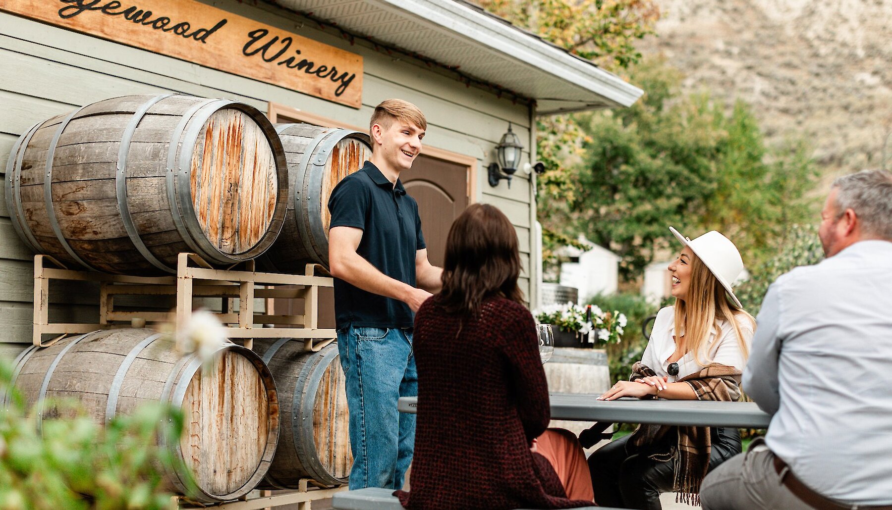 A group of travellers wine tasting on the patio at Sagewood Winery in Kamloops, BC.