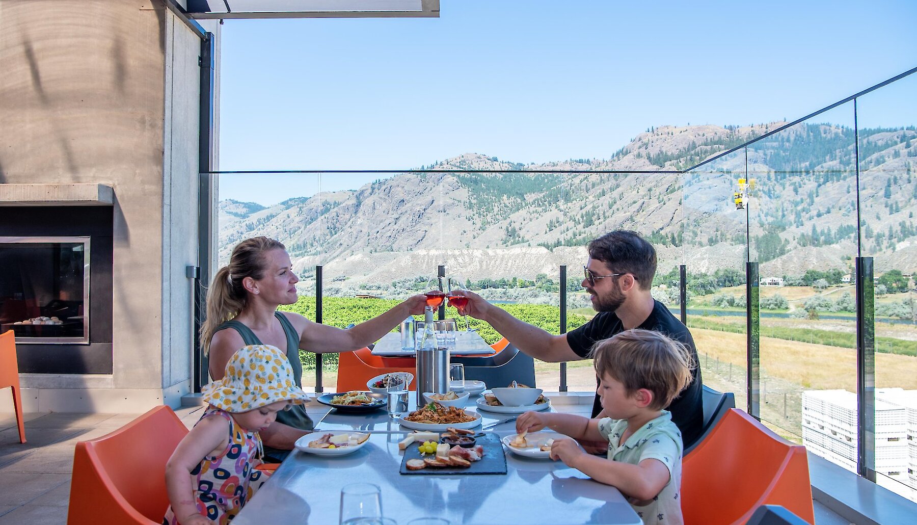 A family patio dining at Monte Creek Winery with stunning river valley views in the background.