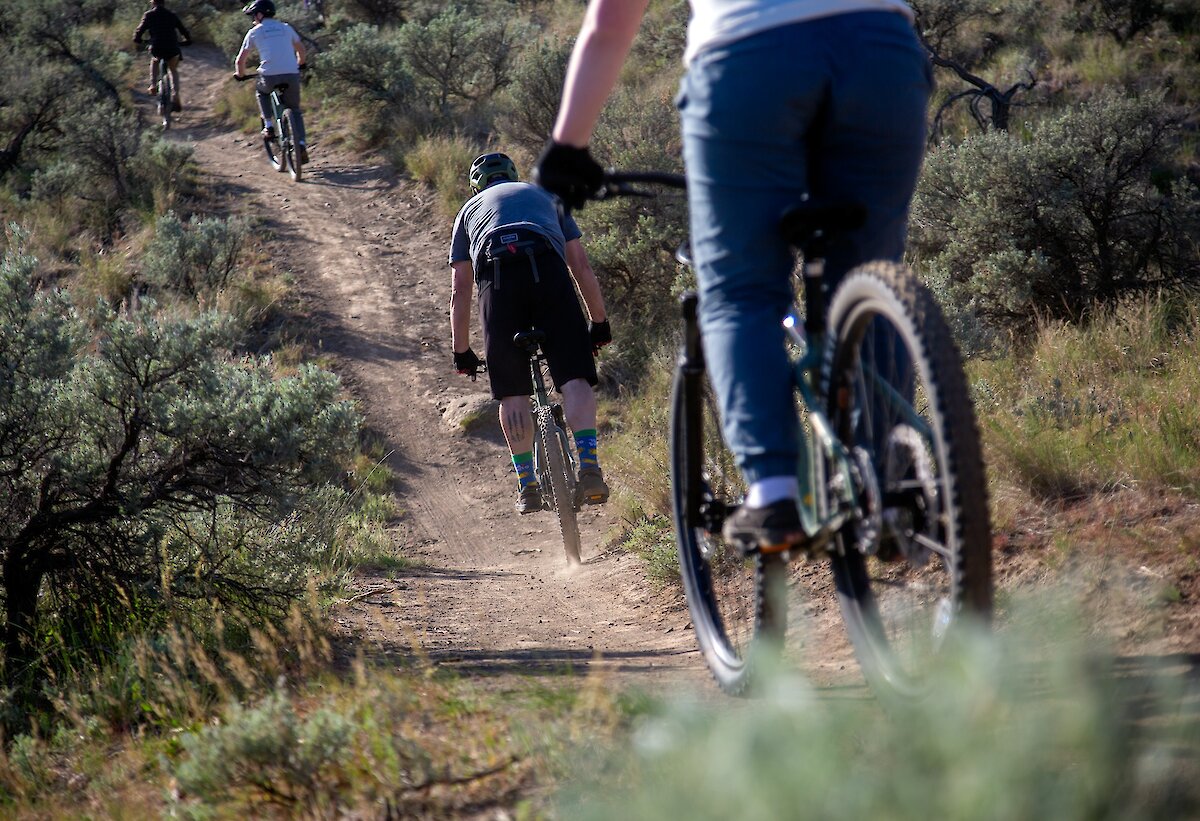 A group of bikers riding along the trail on their mountain bike tour in Kamloops, BC.