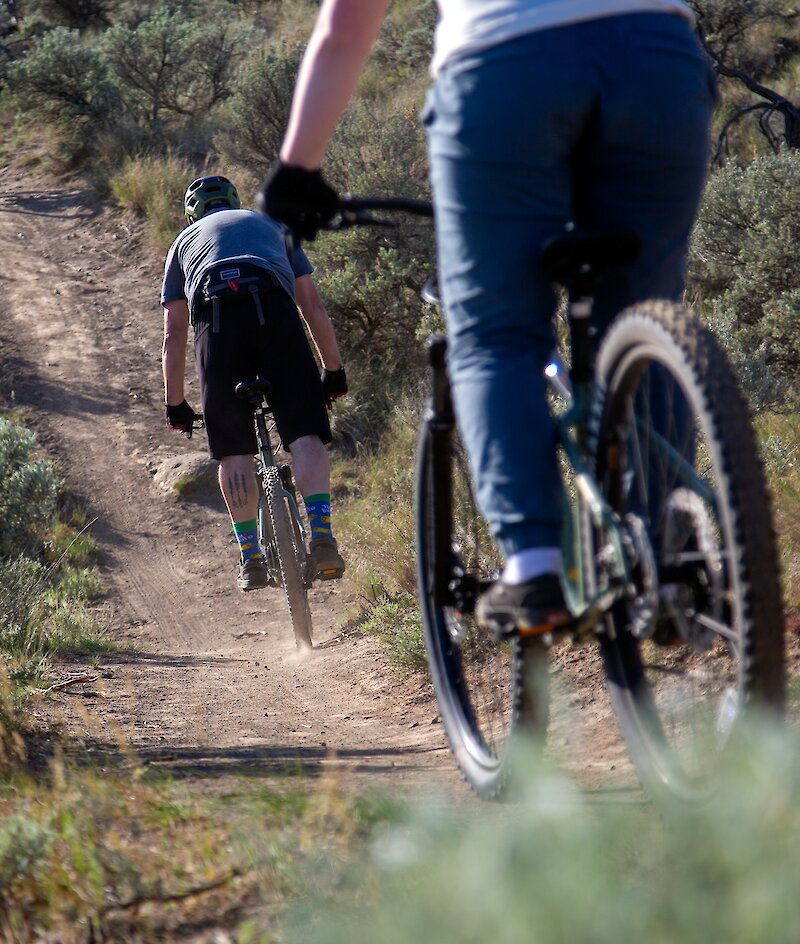 A group of bikers riding along the trail on their mountain bike tour in Kamloops, BC.