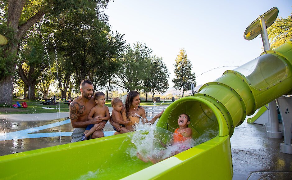 A family cheering while a little girl goes down the waterslide at the splash park located in Riverside Park downtown Kamloops.