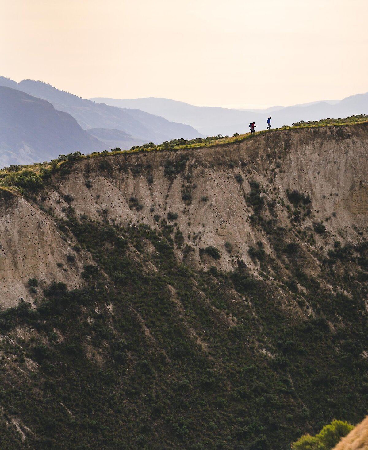 Two people hiking along the ridgeline in Valleyview Nature Park in Kamloops, BC.