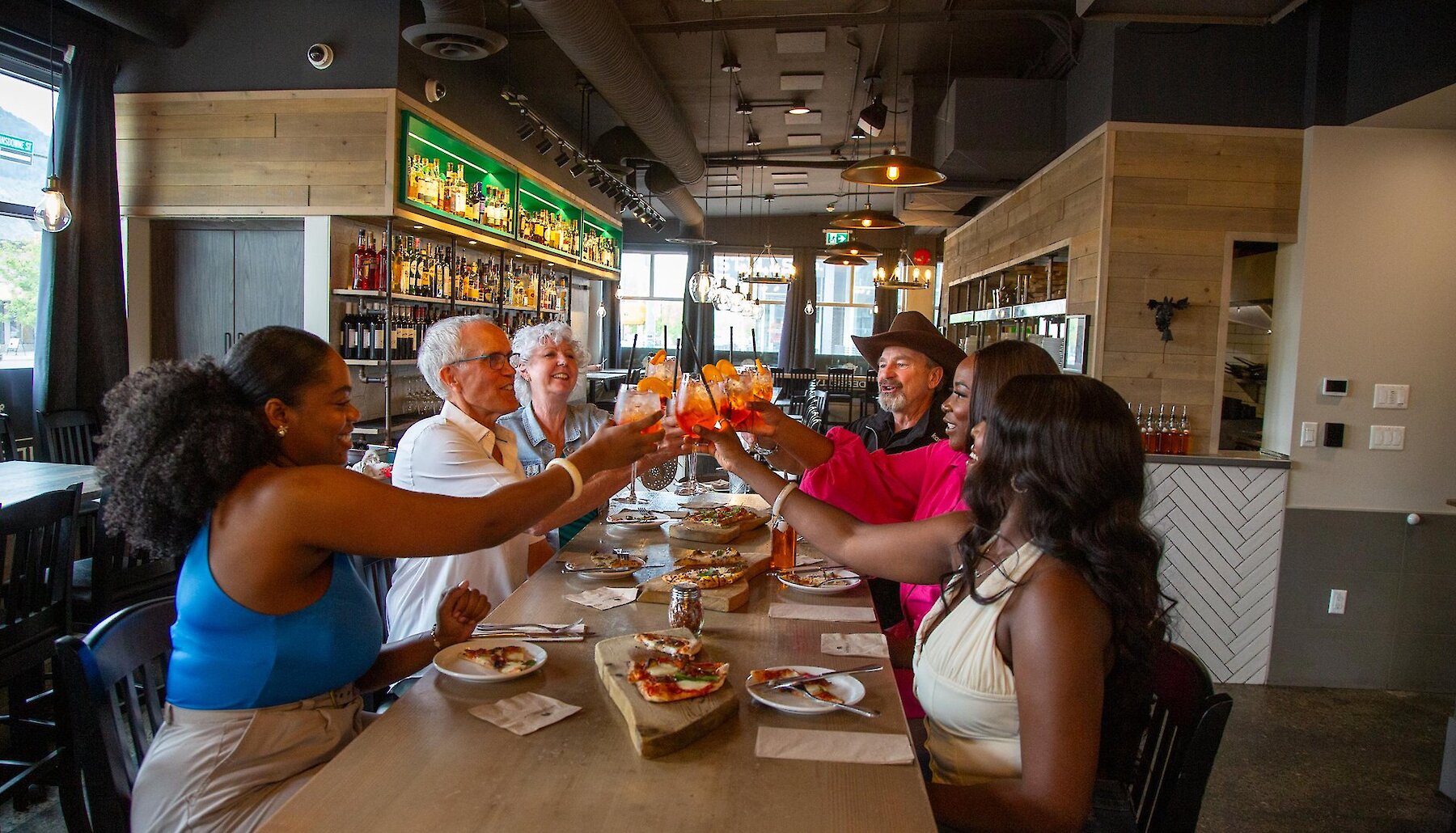 A Local Legends Foodie Tour group holds up their drinks for a cheers at the Underbelly restaurant in downtown Kamloops.