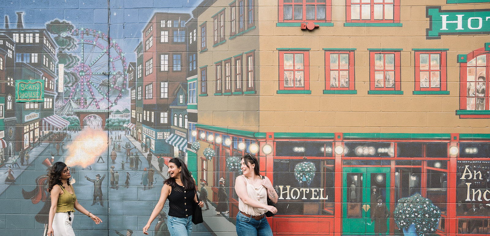 A group of visitors walks along the mural looking up at the artwork in downtown Kamloops,BC.
