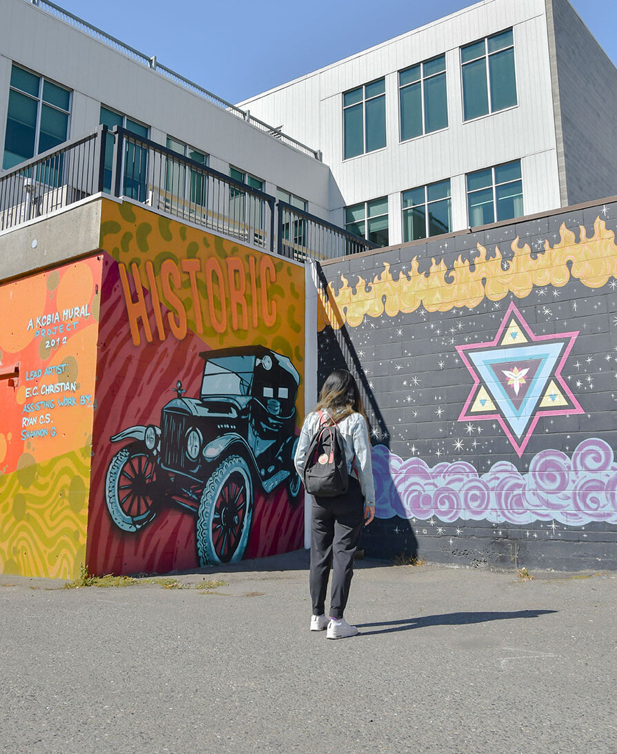 Girl looking the the Homage to the Leland Hotel mural in downtown Kamloops, BC.