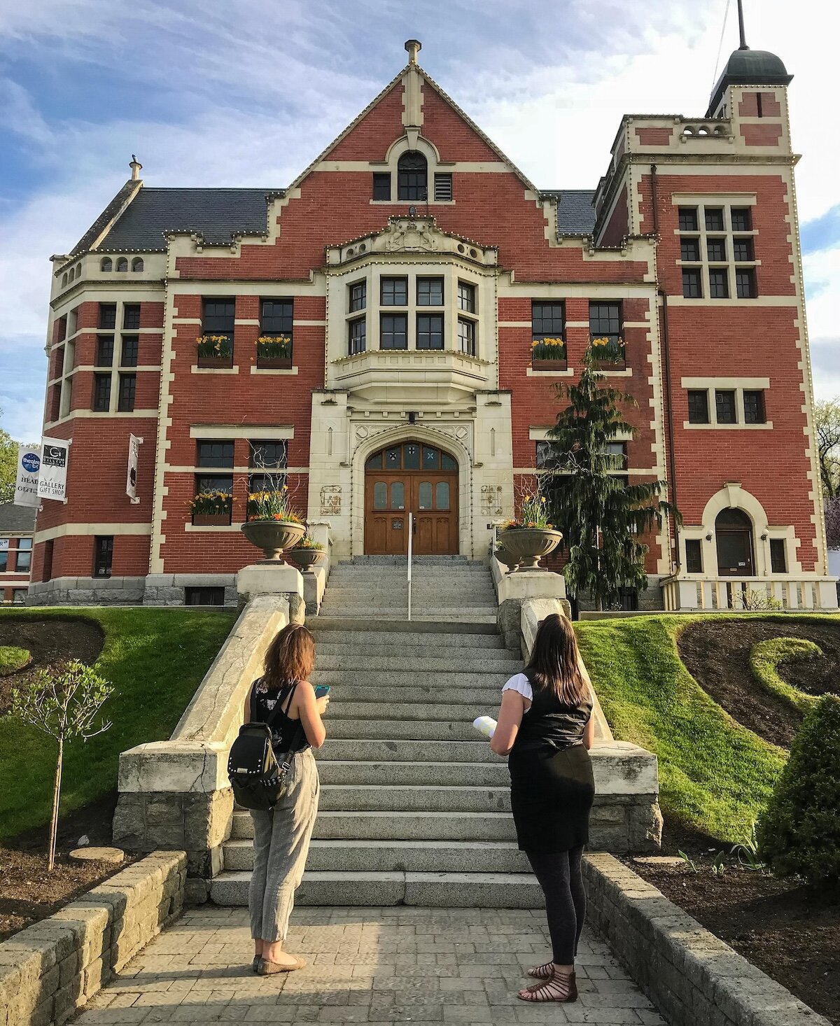 Two visitors looking up at the historic building of the Old Courthouse in downtown Kamloops, BC.