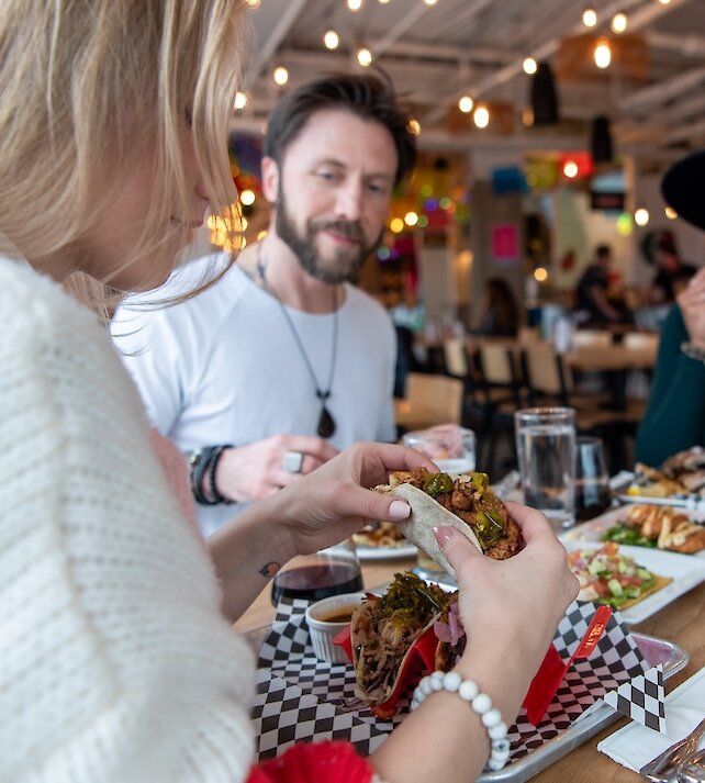A group of friends eating at Yew Street Food Hall on the North Shore in Kamloops, BC.
