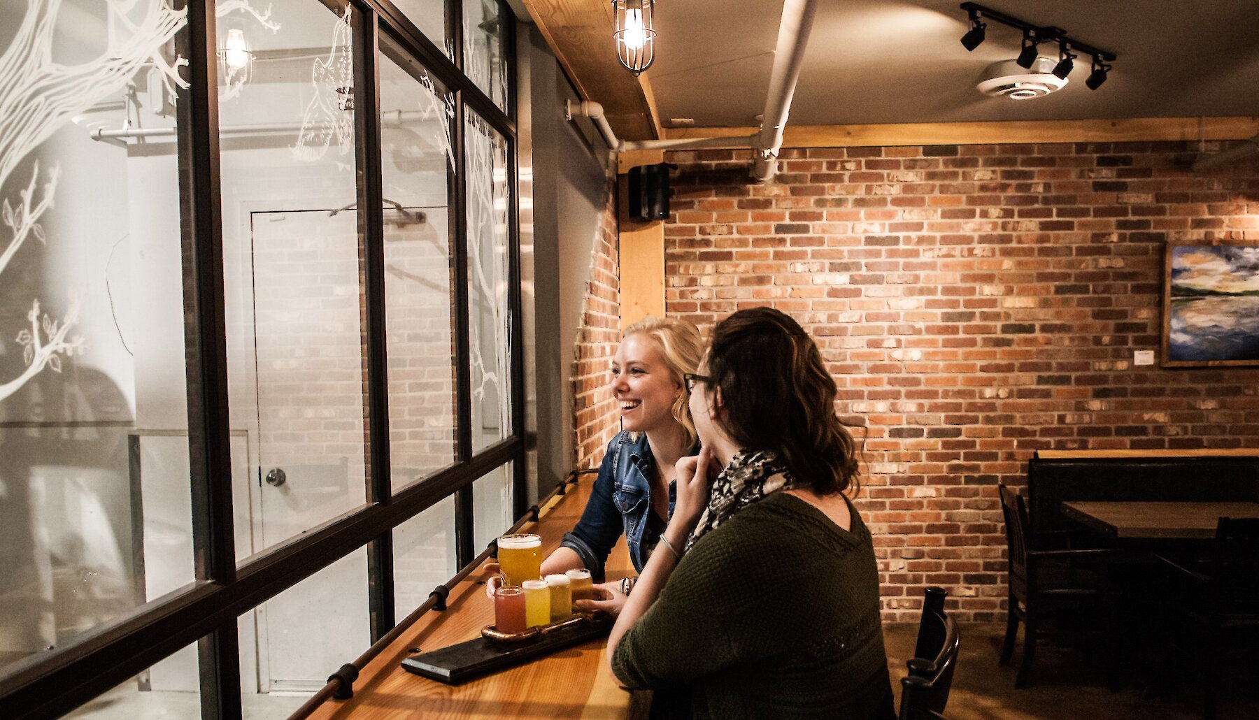 Friends sharing pints in the taproom at Iron Road Brewing in Kamloops.